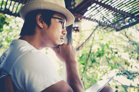 Men are sitting using the tablet relax.の写真素材