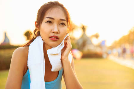 A women is exercising and relaxing at the park.の写真素材