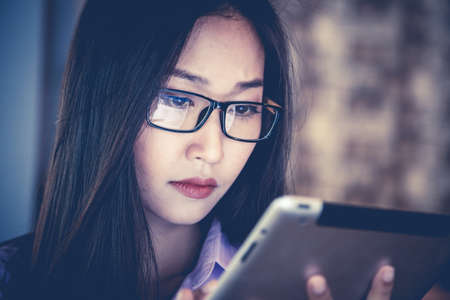 Business woman is usiug a tablet and working in the office.の写真素材