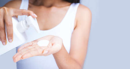 A woman is applying lotion.の写真素材