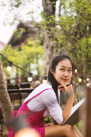 Asian women writing diary in notebook.の写真素材