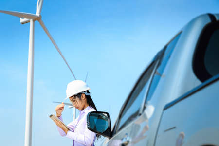 Female engineer is working at wind turbine.