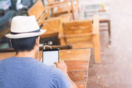 Asian men using a tablet in coffee shop.の写真素材