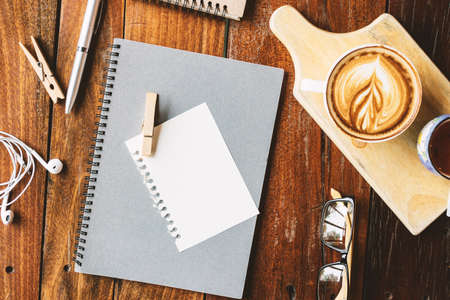 Hot coffee and stationery on the wood table.の写真素材