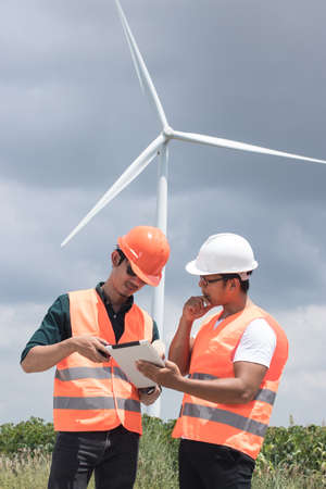 Two male  engineers are working at the wind turbine.の写真素材
