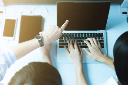 Male businessman and business woman are using laptops.