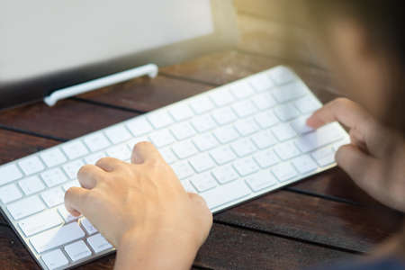Woman is using a tablet and typing keyboard in the garden.