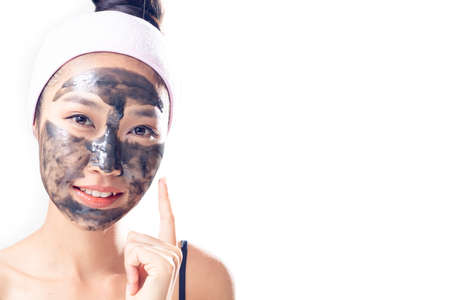 A woman is marking a face with a black mud.の写真素材