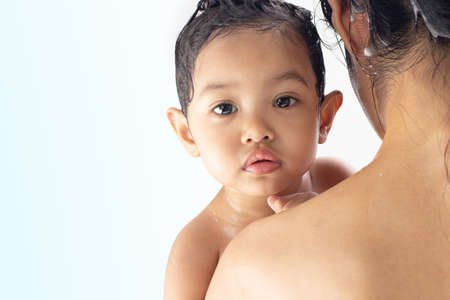 The girl is bathing and washing hair with mother.