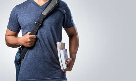 Male students are carrying bags and carrying books.の写真素材