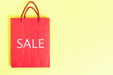 Red paper bag on yellow background.の写真素材