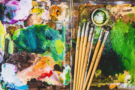 Color fragments stained on paper sheets from art and paint brushes.の写真素材