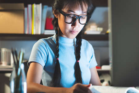 A young girl is using the internet from a computer for homework.の写真素材