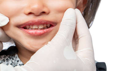 The dentist is examining the baby's teeth.の写真素材