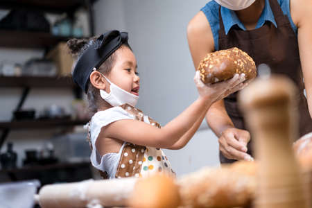 Mother and daughter bake bread together during the quarantine.の写真素材