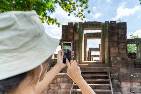 A young tourist is taking pictures of ancient stone castles.の写真素材