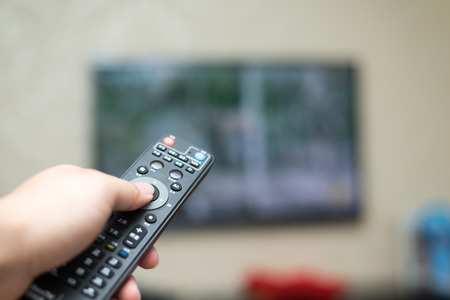 Watching TV and using remote controllerの写真素材