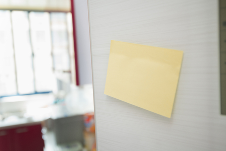 Blank yellow paper on refrigerator door.