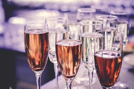 photo of champagner glasses on glass table with bokeh backgroundの写真素材