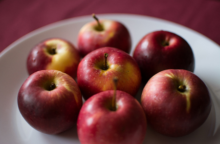 red apples on a plate background for textの写真素材