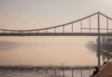 walking bridge above Dnipro river in Kiev in morning fogの写真素材