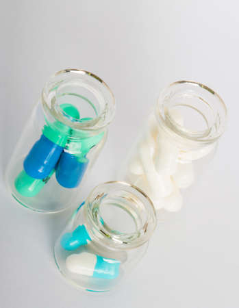 colorful pills in three small glass jarsの写真素材