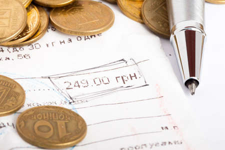 document with number in circle made by black pen and coins on it