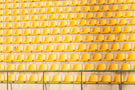 many yellow empty chairs on the soccer fieldの写真素材