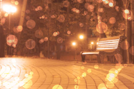 blurred background with bench in autumn park and bokeの写真素材