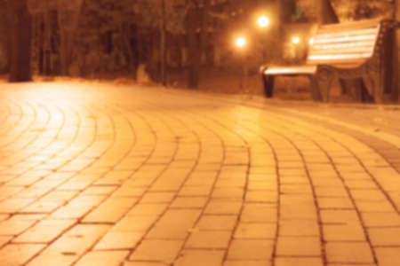 blurred background with bench in autumn night parkの写真素材