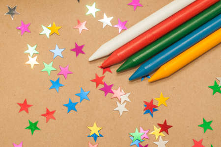 colorful wax crayons and  stars on brown kraft backgroundの写真素材