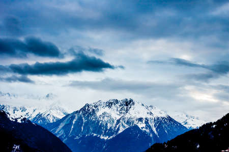 Sunset over winter Alps with many clouds