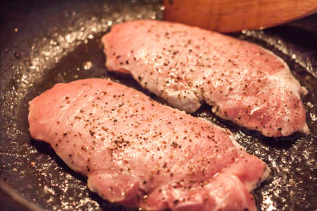 cooking pork steaks in a frying panの写真素材