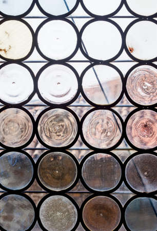 ancient castle window made of round shaped pieces glassの写真素材