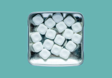 mint sweets in metal box against the blue background