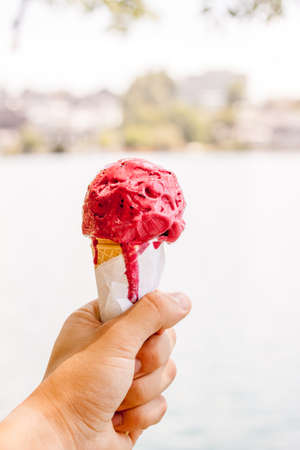red ice cream cone in the handの写真素材