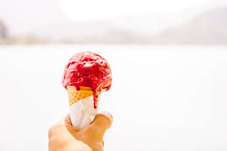 red ice cream cone in the hand