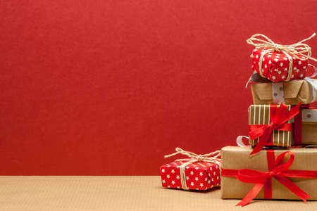 pile of different beautiful christmas gifts on red backgroundの写真素材