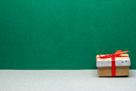 one small christmas gift on green and grey craft background