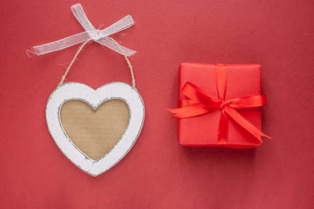 wooden heart with free space and gift on red background