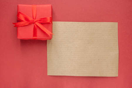 gift box and empty brown paper on red backgroundの写真素材