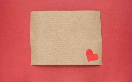 brown craft paper with handmade heart on red backgroundの写真素材
