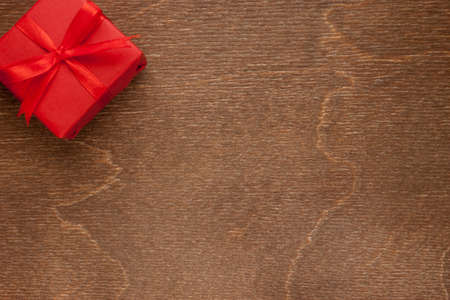 one small red christmas gift on wooden backgroundの写真素材