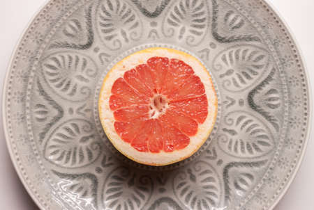 red grapefruit in grey plateの写真素材
