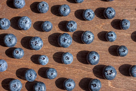 big blueberries wooden background bright shadowsの写真素材