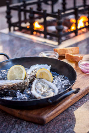 fresh opened oysters fireplace backgroundの写真素材