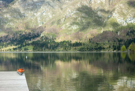Mountain lake orange kayak crystal clear waterの写真素材