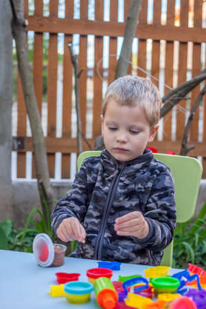 cute little boy playing with plasticine