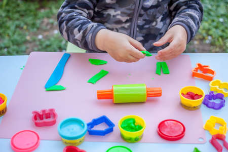 cute little boy playing with plasticineの写真素材
