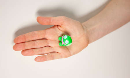 female hand showing small green plasticine monsterの写真素材